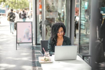 Resilient freelancer sitting outside a cafe at her laptop