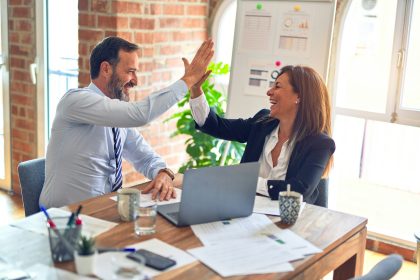 man in white dress shirt sitting beside woman in black long sleeve shirt; repeat business