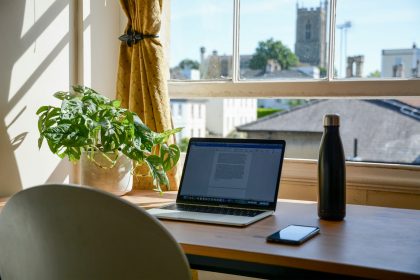 macbook pro on brown wooden table in home office.