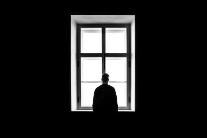 man standing in front of the window; Loneliness Of Self-Employment