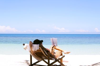 woman sits on brown wooden beach chair; Plan for Time Off