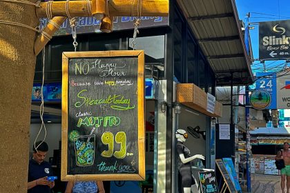 a woman standing in front of a store holding a sign; Undercharging