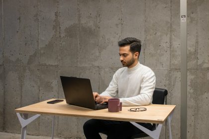 a man sitting at a table using a laptop computer; financially mature freelancers