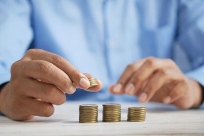 a person stacking coins on top of a table; quarterly tax mistakes freelancers