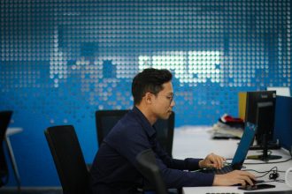 a man sitting at a desk using a laptop computer; what to check in a tool’s privacy policy
