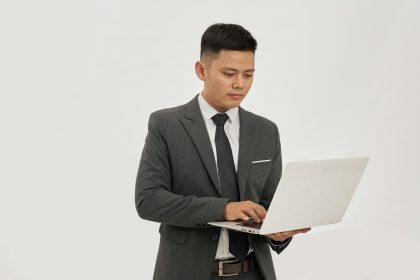 A businessman types on a laptop; business bank account setup