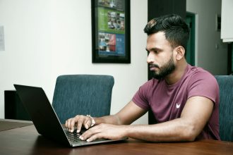 a man sitting in front of a laptop computer; trading tools