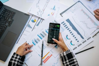 A top view on charts and smartphone in an office, showcasing data analytics.; Quickbooks Self-Employed