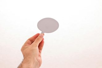 Photo of a hand holding a blank speech bubble, perfect for mockups and design concepts.; Master's in psychology