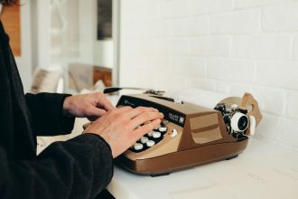 person in black long sleeve shirt using brown and white rotary phone; how to become a freelance writer