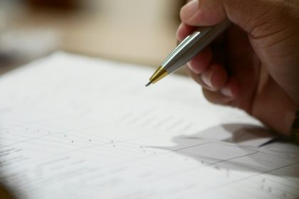 a hand holding a pen; freelance contract template