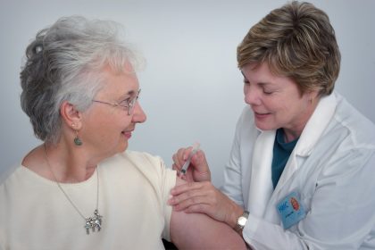 woman inject a woman on left shoulder; online nurse practitioner program