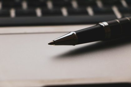 a pen sitting on top of a paper next to a keyboard; freelance proposal