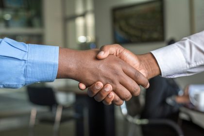 two people shaking hands; hiring your first employee