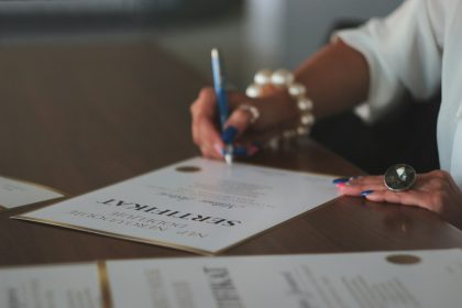 a woman writing on a piece of paper; independent contractor agreement