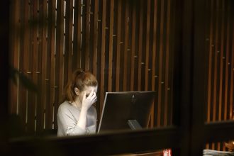 a woman sitting in front of a laptop computer; burn out