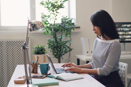 a woman sitting at a desk using a laptop computer; freelance accountant