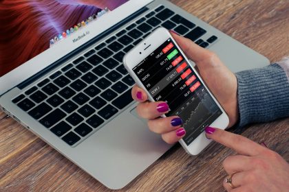person holding silver iPhone 6; investment apps for beginners