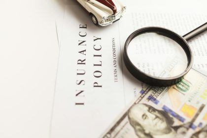 a magnifying glass sitting on top of a piece of paper; self employed liability insurance