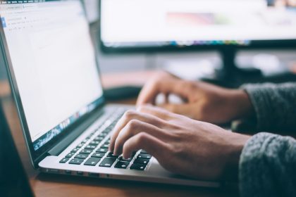 person using MacBook Pro; best crm software