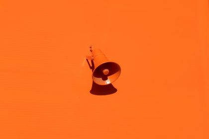orange megaphone on orange wall; AI brand content platform