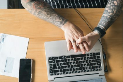 person using macbook pro on brown wooden table; freelance proposal