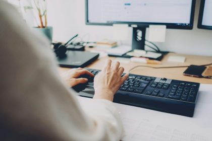 a person is typing on a computer keyboard; what does a virtual assistant do