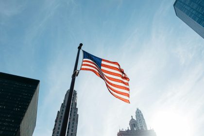 USA flag on pole at the city during day; Investing in All of America Act