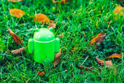 green Android robot toy on grass; Finix unattended payment terminal