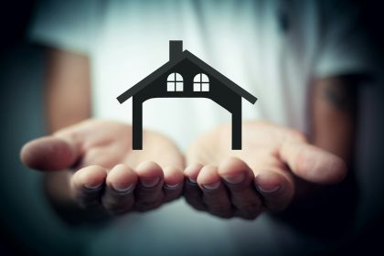 Hands holding a silhouette of a house; real estate virtual assistant