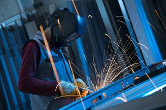 A welder uses sparks to join metal.; robotic welding