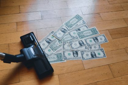 a pile of money sitting on top of a wooden floor; small business inflation