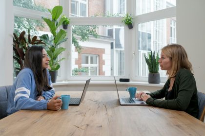 woman in black jacket sitting beside woman in blue long sleeve shirt; B2B vendor financing
