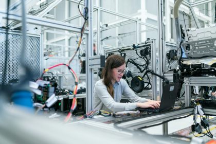 woman in white long sleeve shirt using black laptop computer; SBA Manufacturing grant