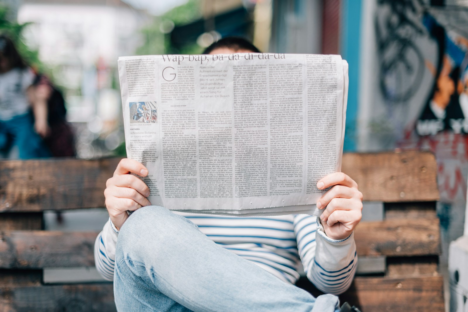 man sitting on bench reading newspaper; April CPI 2026