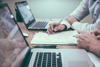 person holding pencil near laptop computer; what does a consultant do