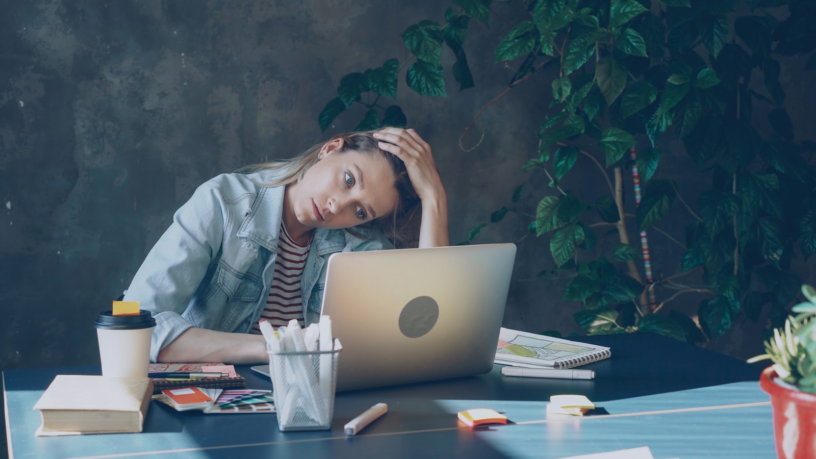 A woman appears stressed while working on laptop.; small business financial stress