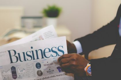 person wearing suit reading business newspaper; is an llc a business license