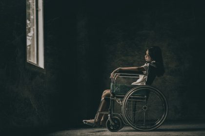 a woman in a wheelchair looking out a window; short-term disability