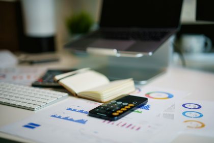 office desk with smartphone and financial charts; self-employed painter hourly rate