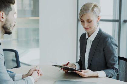 Woman in suit reviews document with man.; what is a retainer fee