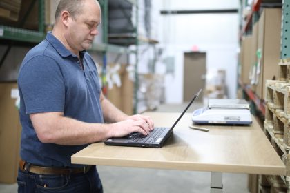 man in blue polo shirt using laptop computer; ISM Manufacturing PMI May 2026