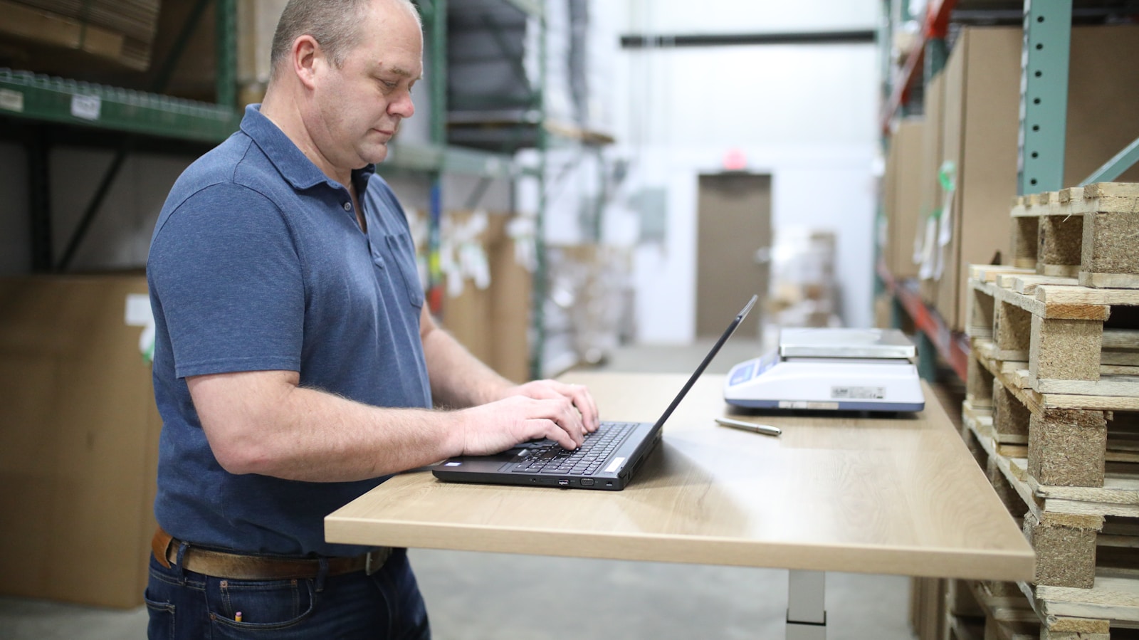 man in blue polo shirt using laptop computer; ISM Manufacturing PMI May 2026