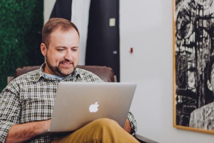man smiling and using MacBook; Fed interest rate decision June 2026