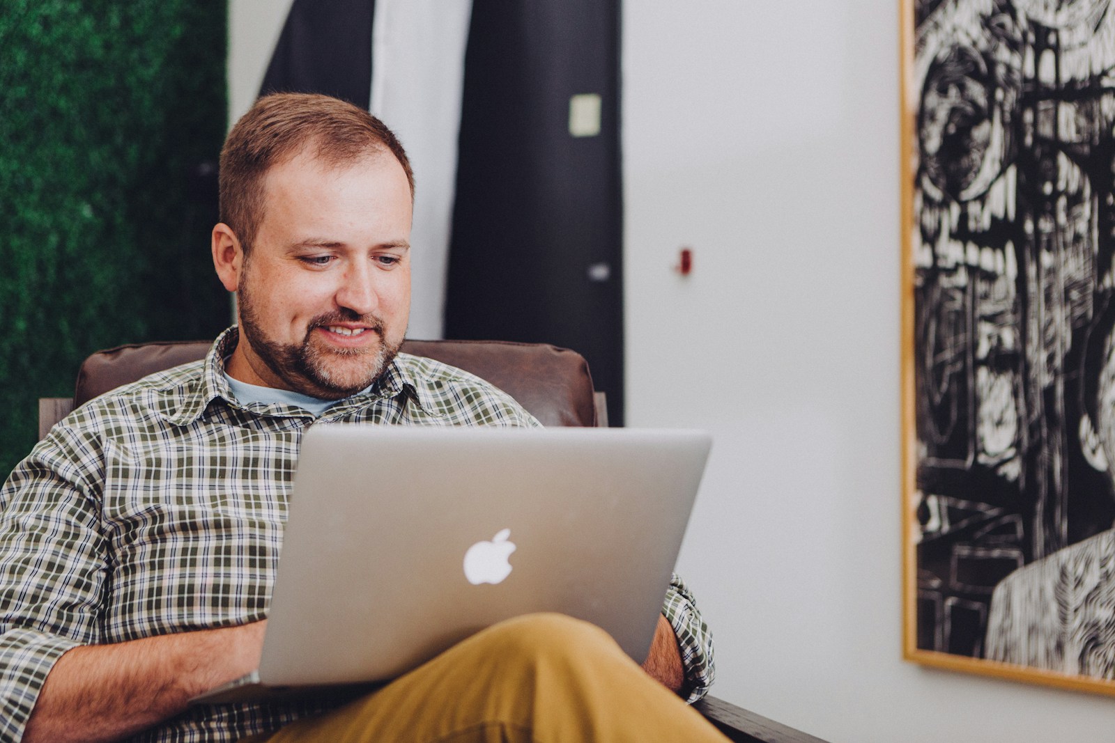 man smiling and using MacBook; Fed interest rate decision June 2026