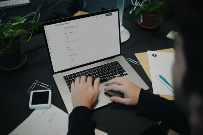 A person sitting at a desk using a laptop computer; SumUp invoicing