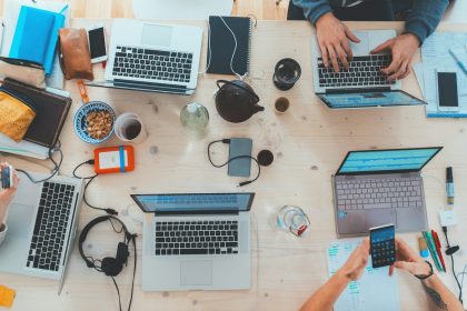 people sitting down near table with assorted laptop computers; what is a fiscal year