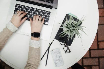 person using laptop computer beside aloe ; vera; solopreneur operating system