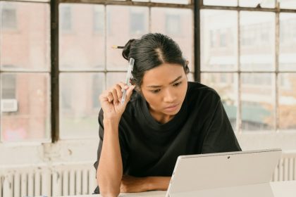 a woman sitting at a table using a laptop computer; May PPI report 2026