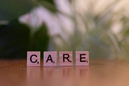 A wooden block spelling care on a table; 2027 ACA premium increase